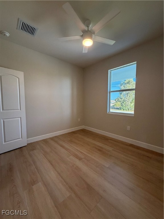 101 Pennfield Street Lehigh Acres, FL 33974 - Photo 21 of 29 an empty room with wooden floor cabinet and windows