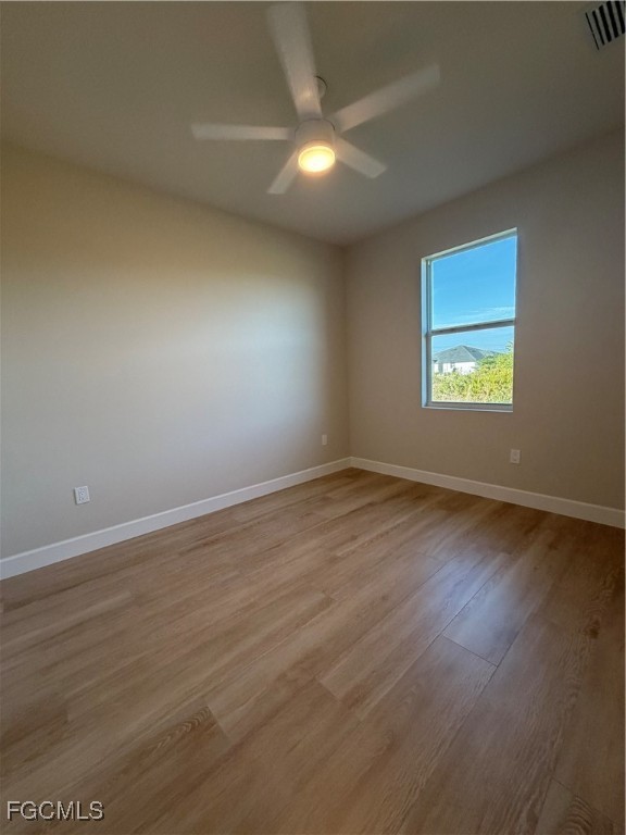 101 Pennfield Street Lehigh Acres, FL 33974 - Photo 23 of 29 an empty room with wooden floor and windows