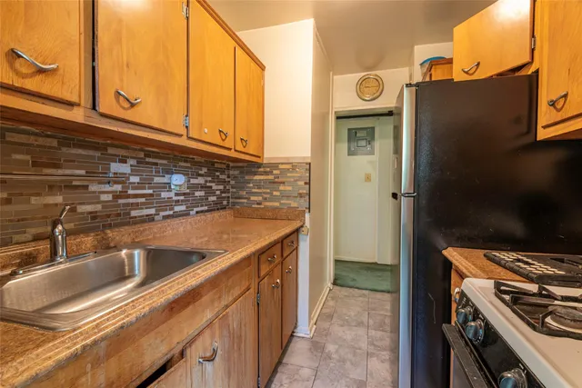 a kitchen with stainless steel appliances granite countertop a sink and a refrigerator