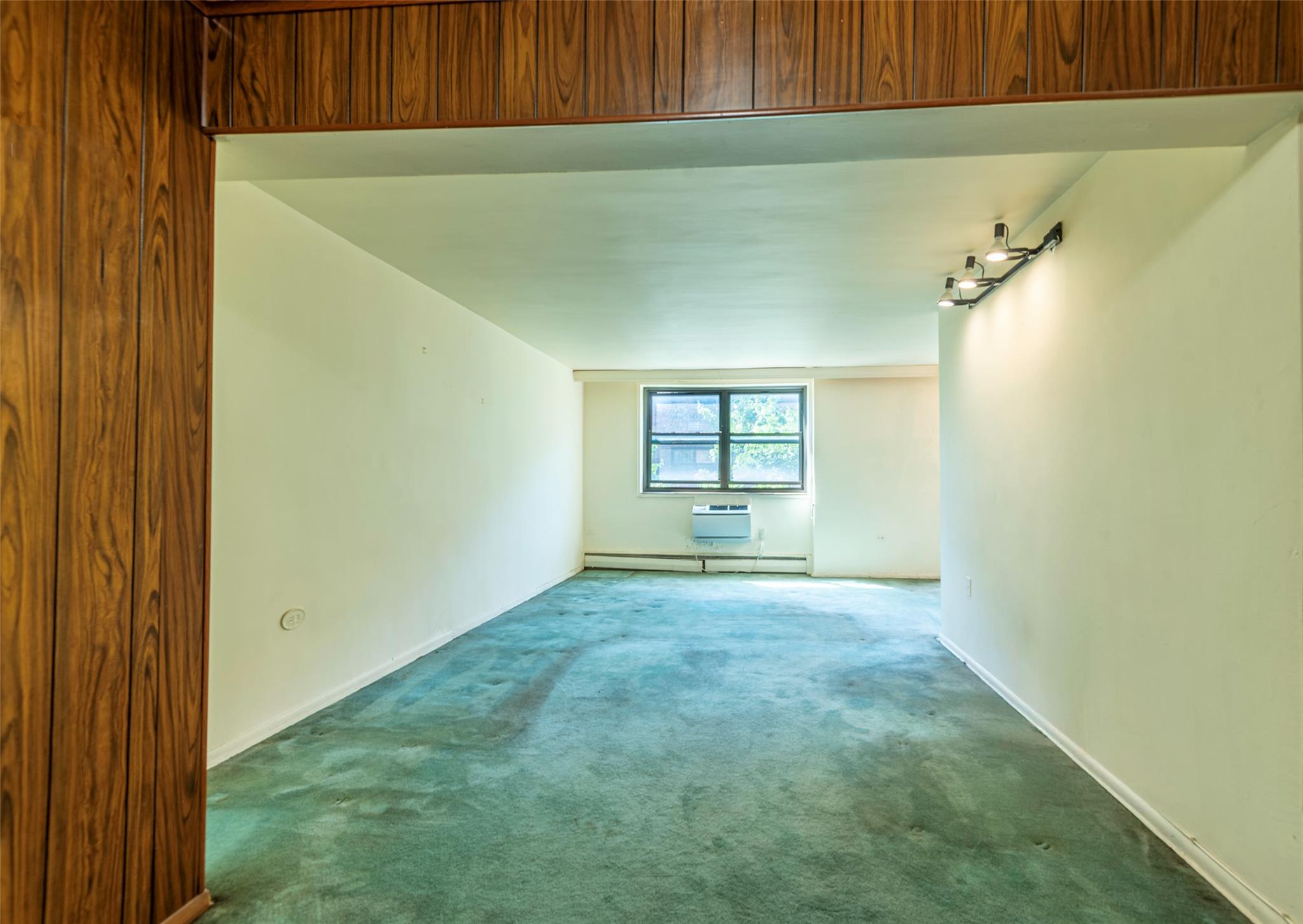 99-35 59th Avenue, Unit 4K Queens, NY 11368 - Photo 7 of 24 Carpeted spare room with baseboard heating and baseboards