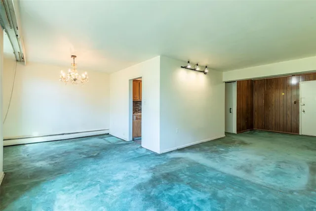 an empty room with closet and a chandelier fan