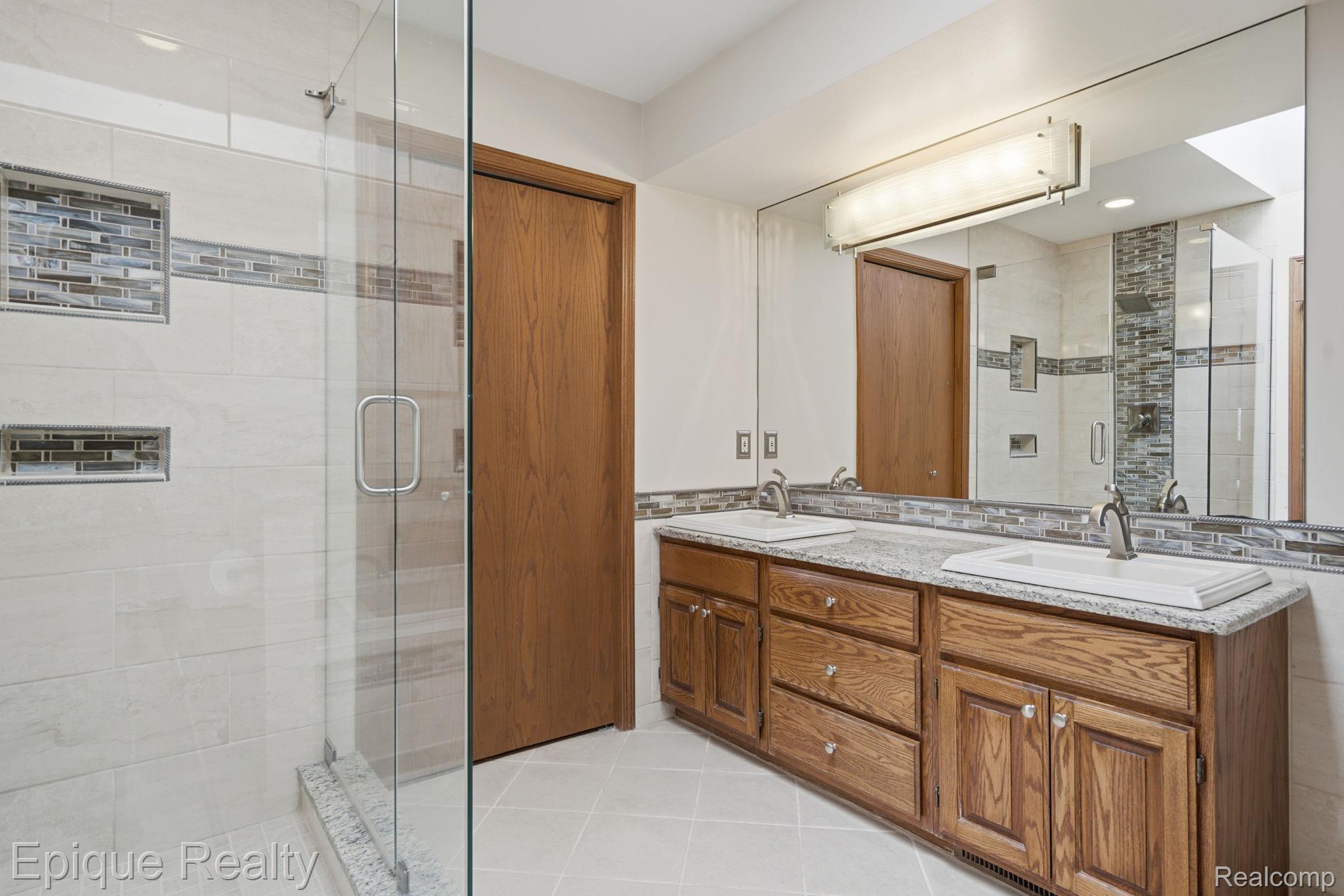 6607 Ridgeview Drive Clarkston, MI 48346 - Photo 22 of 25 Bathroom featuring double vanity, a shower stall, light tile patterned flooring, and recessed lighting