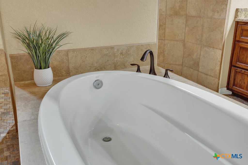 7607 Sky Loop Garden Ridge, TX 78266 - Photo 7 of 43 a bathroom with a tub