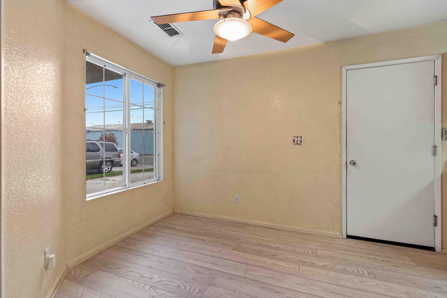 310 West F Street Turlock, CA 95380 - Photo 5 of 27 a view of an empty room with wooden floor and a window