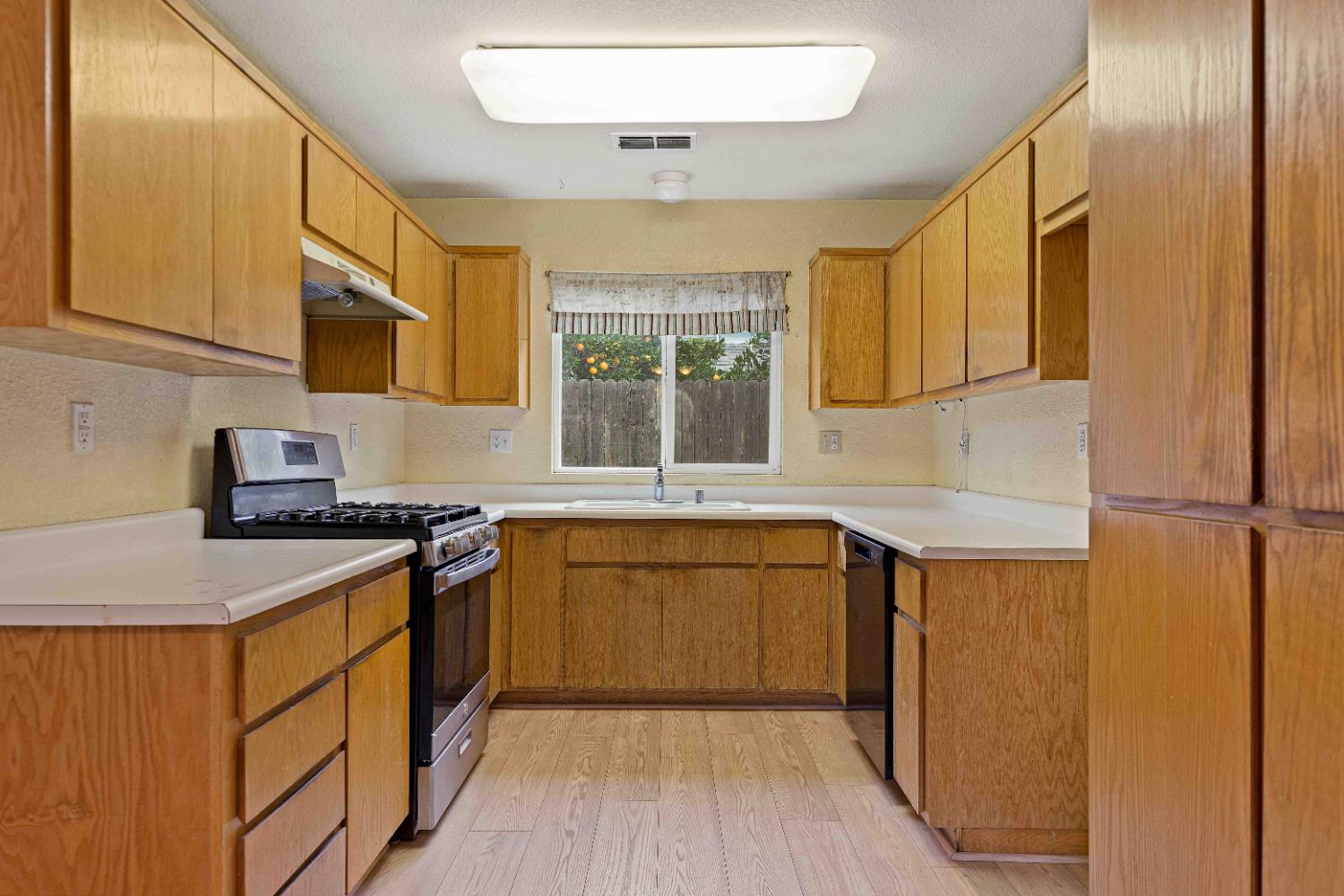 310 West F Street Turlock, CA 95380 - Photo 6 of 27 a kitchen with stainless steel appliances granite countertop a stove a sink and a refrigerator