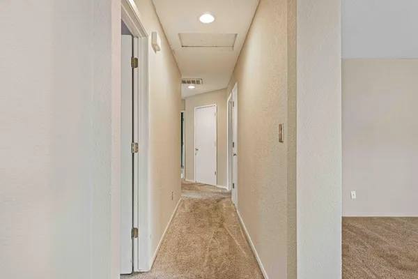a view of a hallway with wooden floor and entryway