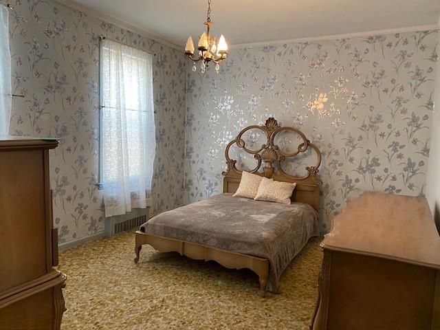 4021 Avenue R Brooklyn, NY 11234 - Photo 11 of 20 a bedroom with a bed and a chandelier