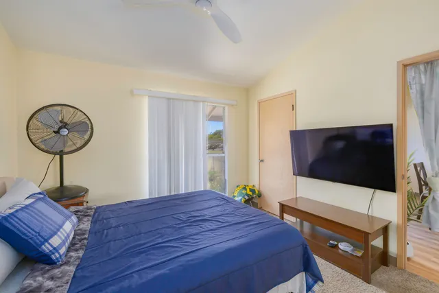 a bedroom with a bed window and a flat screen tv