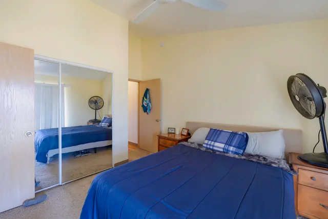 a bedroom with a bed and a lamp on the dresser