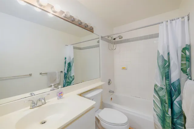 a bathroom with a sink a toilet a tub and shower