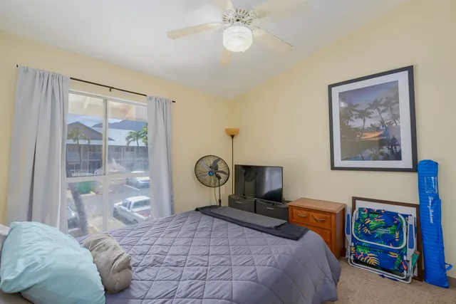 a bedroom with a bed a chandelier and a window