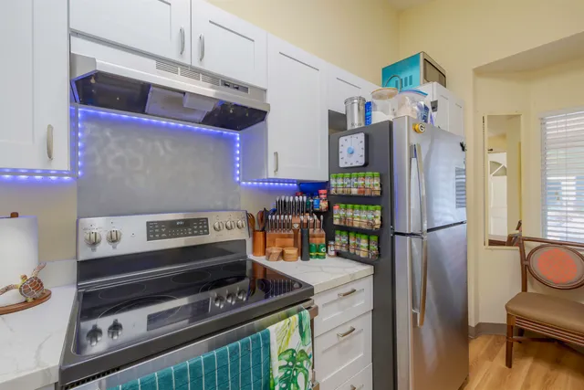 a kitchen with stainless steel appliances granite countertop a refrigerator and a stove