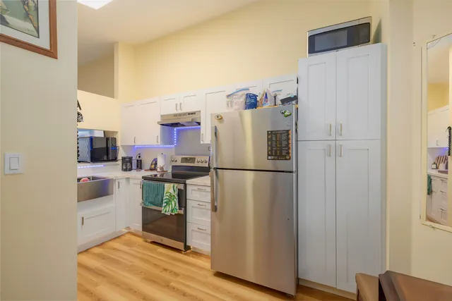 a white refrigerator freezer and a stove sitting inside of a kitchen