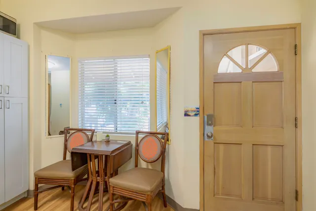 a view of a a dining room with furniture window and wooden floor
