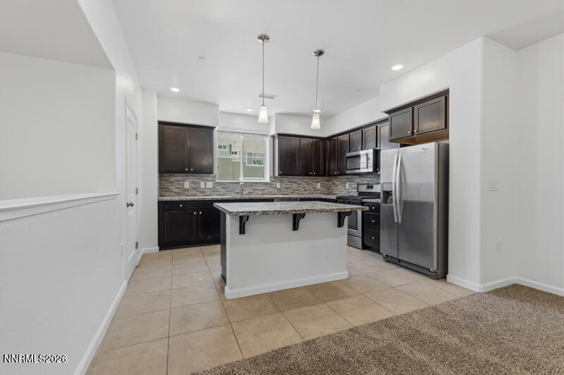 285 Mark Jeffrey Lane Reno, NV 89503 - Photo 3 of 20 a large kitchen with stainless steel appliances kitchen island granite countertop a refrigerator a stove a sink and a microwave