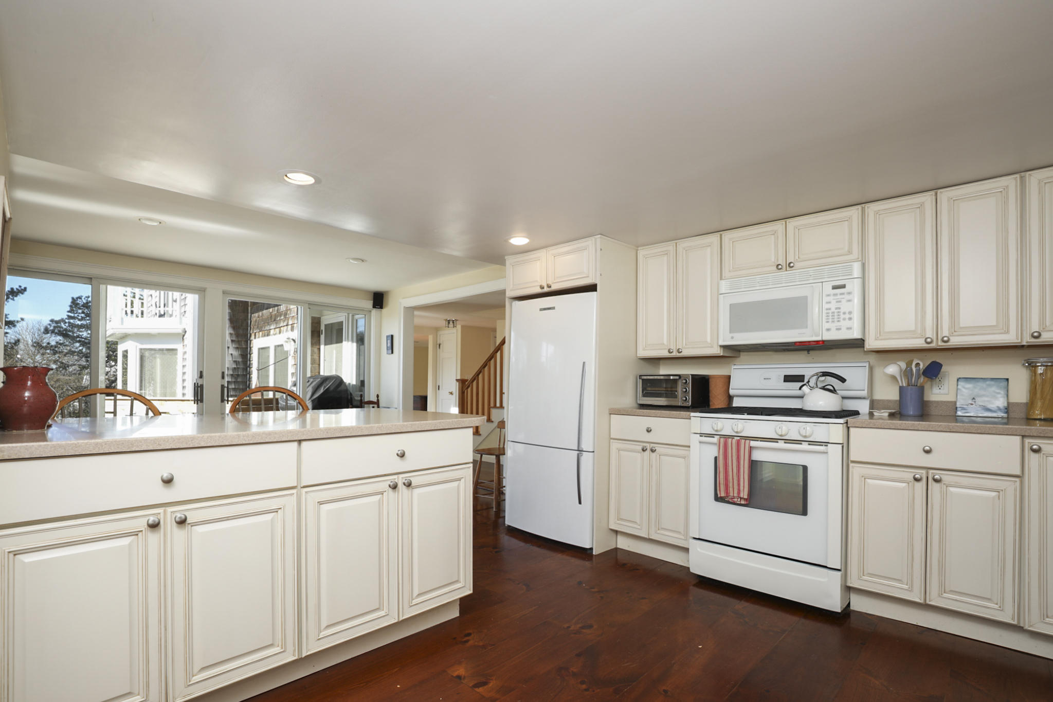 145 Barley Neck Road Orleans, MA 02653 - Photo 11 of 39 a kitchen with white cabinets and white appliances