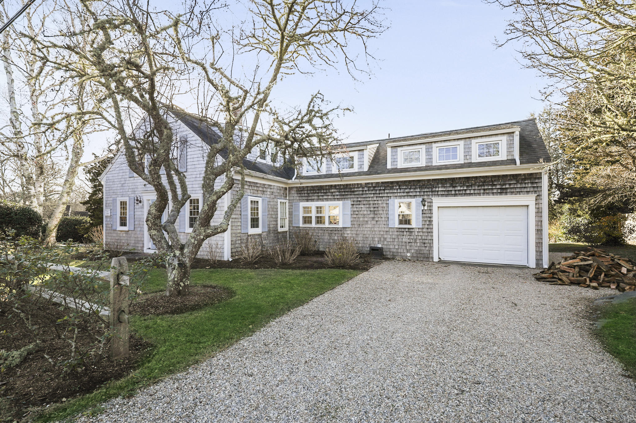 145 Barley Neck Road Orleans, MA 02653 - Photo 32 of 39 a front view of a house with a garden and trees