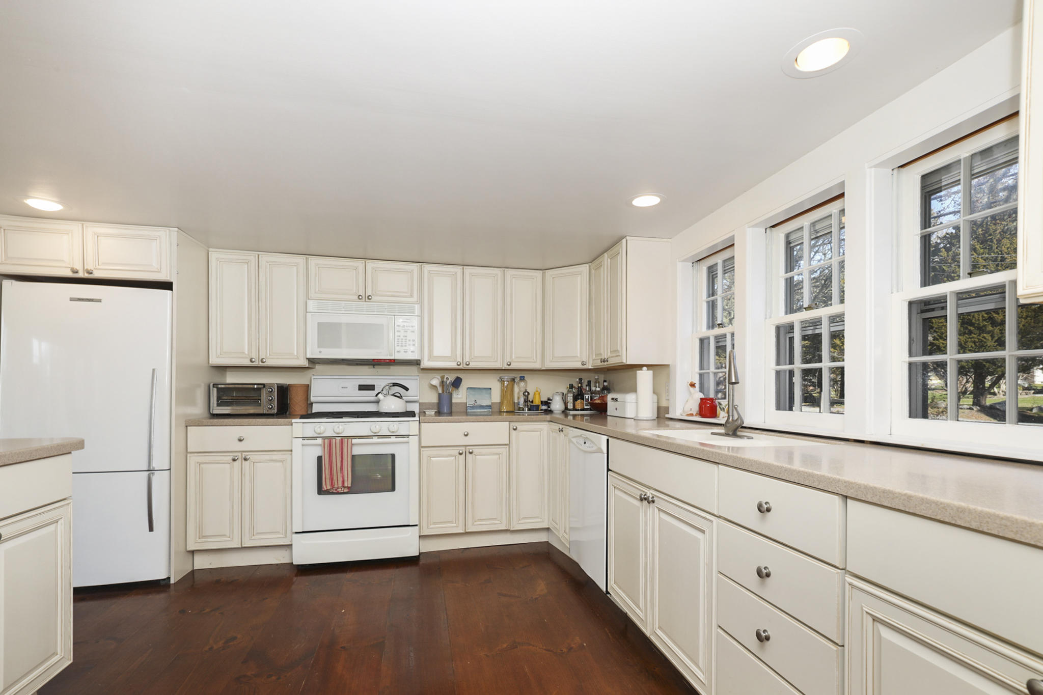 145 Barley Neck Road Orleans, MA 02653 - Photo 10 of 39 a kitchen with white cabinets and white appliances