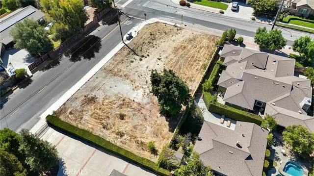an aerial view of residential houses with outdoor space and trees