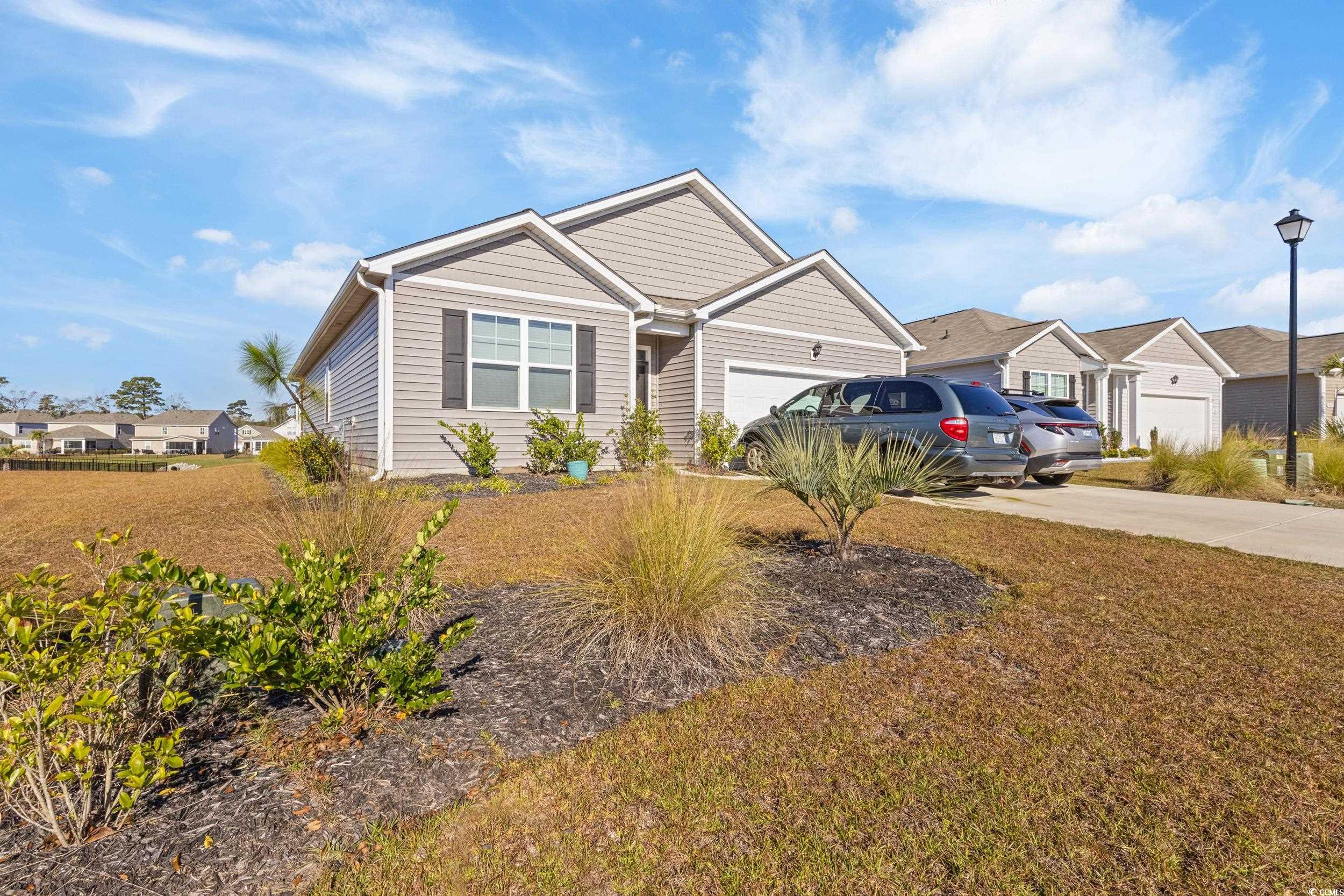 View of front facade with concrete driveway, a front lawn, a residential view, and an attached garage