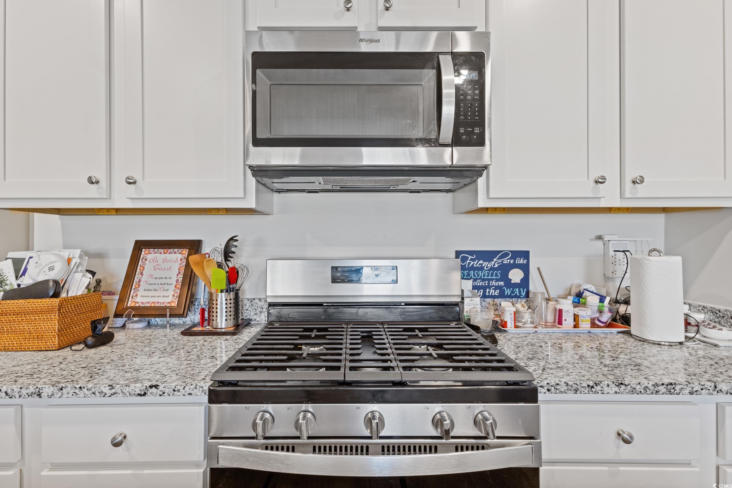 8034 Strudwick Drive Little River, SC 29566 - Photo 16 of 36 Kitchen featuring appliances with stainless steel finishes, white cabinets, and light stone counters