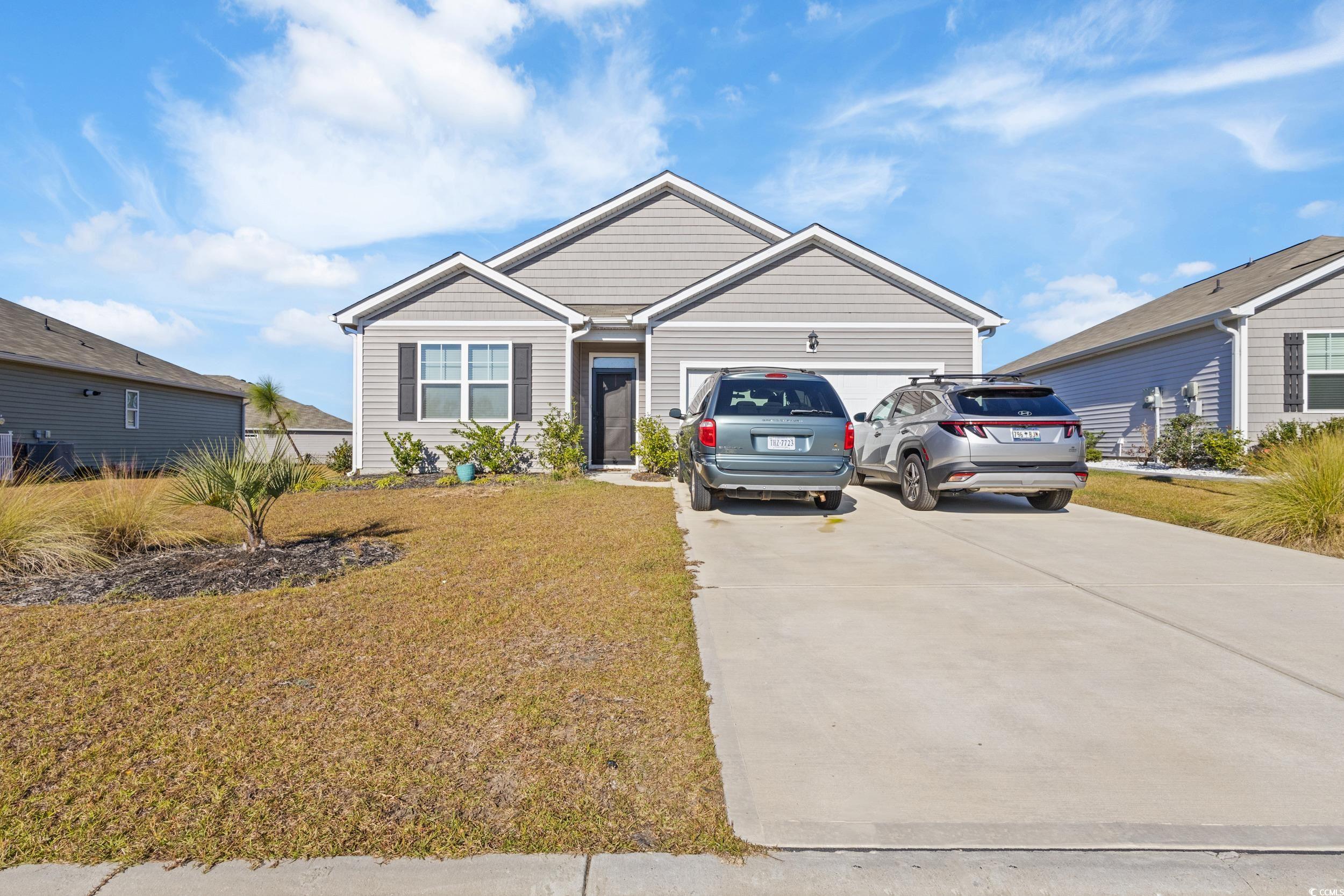 8034 Strudwick Drive Little River, SC 29566 - Photo 2 of 36 View of front of house featuring a front yard, concrete driveway, and a garage