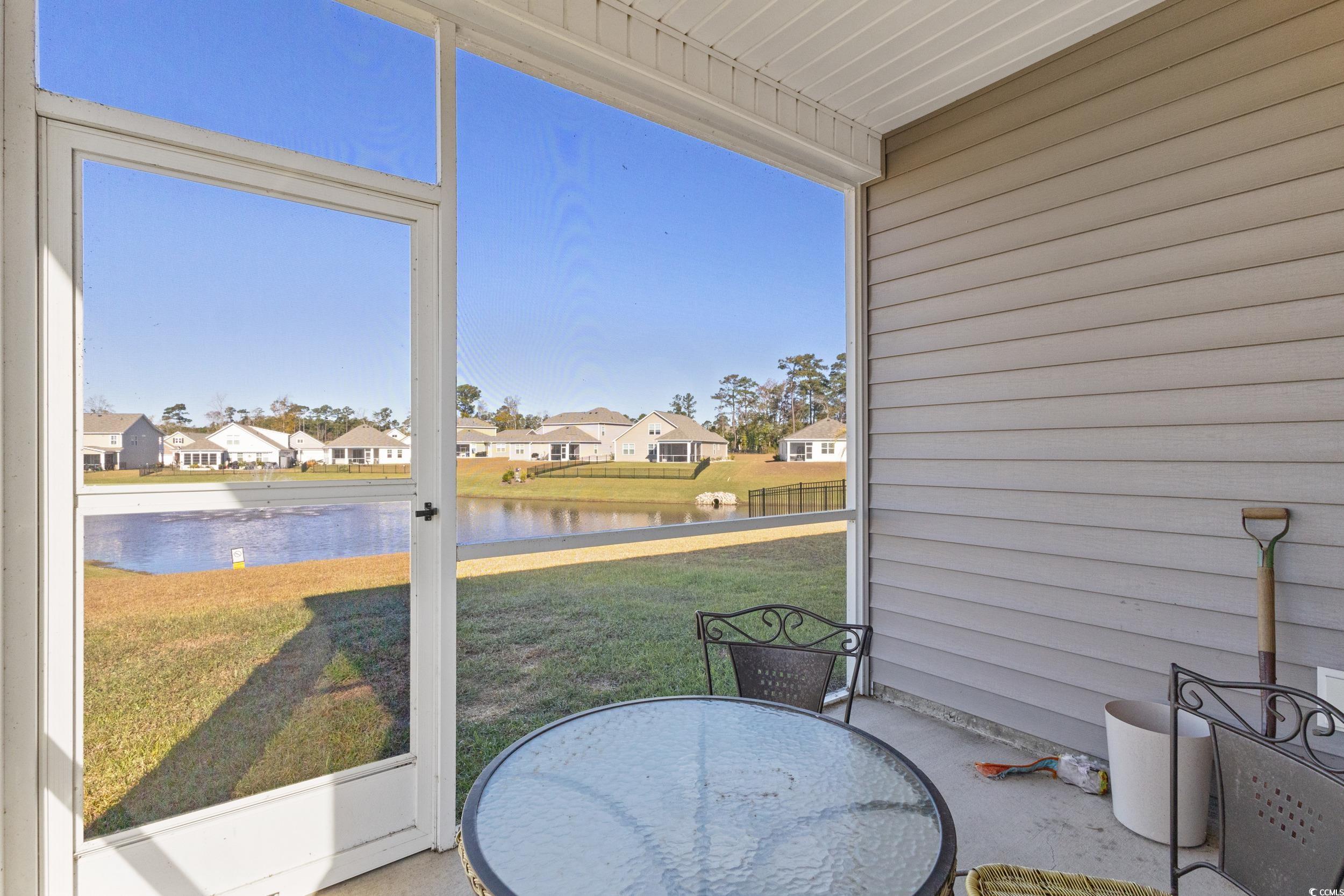 8034 Strudwick Drive Little River, SC 29566 - Photo 23 of 36 Sunroom featuring a water view, a residential view, healthy amount of natural light, and outdoor dining space