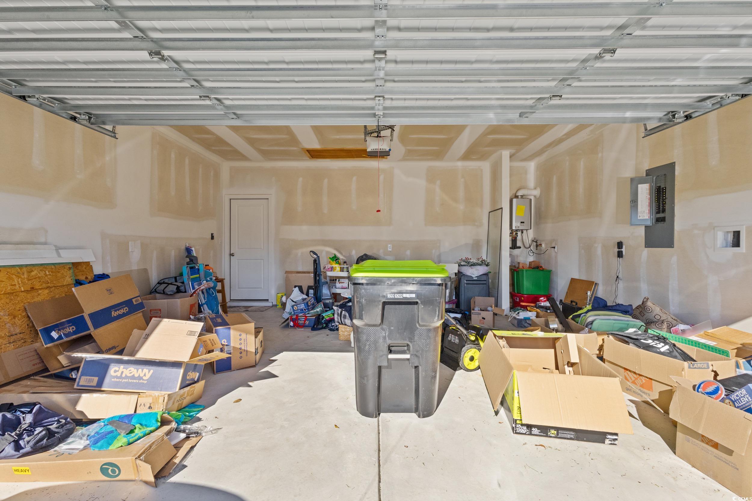 8034 Strudwick Drive Little River, SC 29566 - Photo 27 of 36 Garage featuring electric panel and a garage door opener