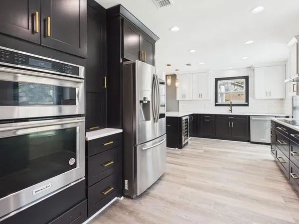 a kitchen with stainless steel appliances kitchen island granite countertop a refrigerator stove and sink