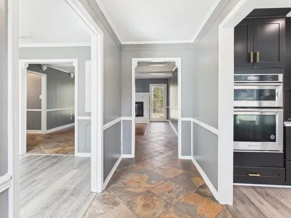 a view of a hallway with wooden floor kitchen view and living room
