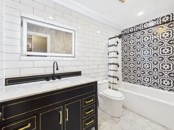 a bathroom with a granite countertop toilet sink and mirror