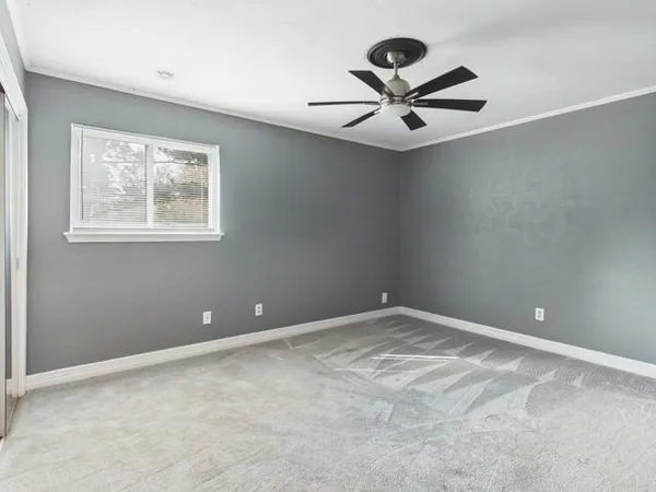 a view of an empty room with a ceiling fan