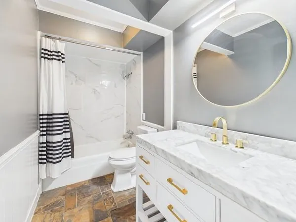 a bathroom with a sink a toilet and a mirror