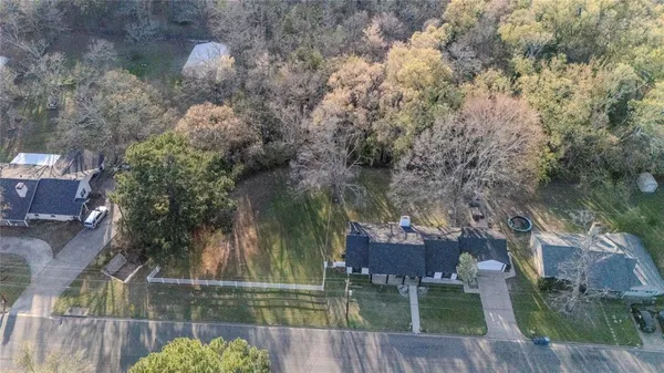 an aerial view of a house with a yard and wooden fence