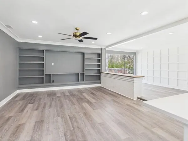 a view of empty room with wooden floor and window