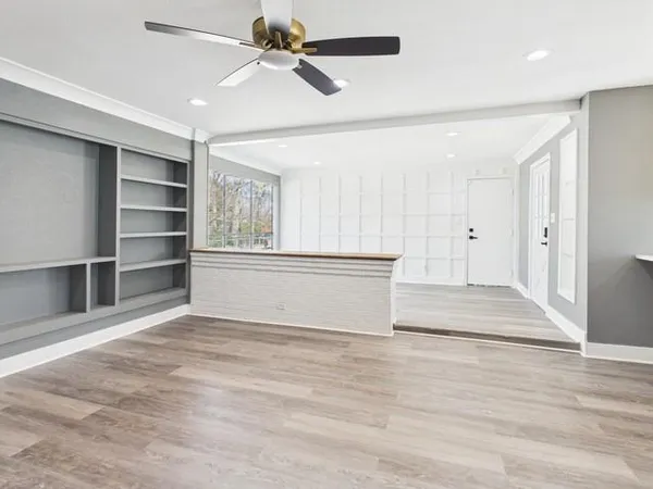 a view of an empty room with a window and a ceiling fan