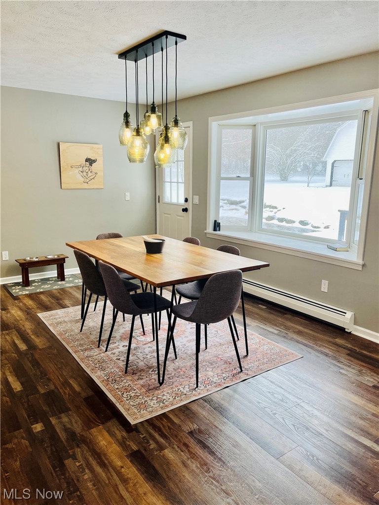 13655 Spring Street Burton, OH 44021 - Photo 24 of 48 Dining area featuring baseboard heating, dark hardwood / wood-style flooring, a textured ceiling, and a chandelier