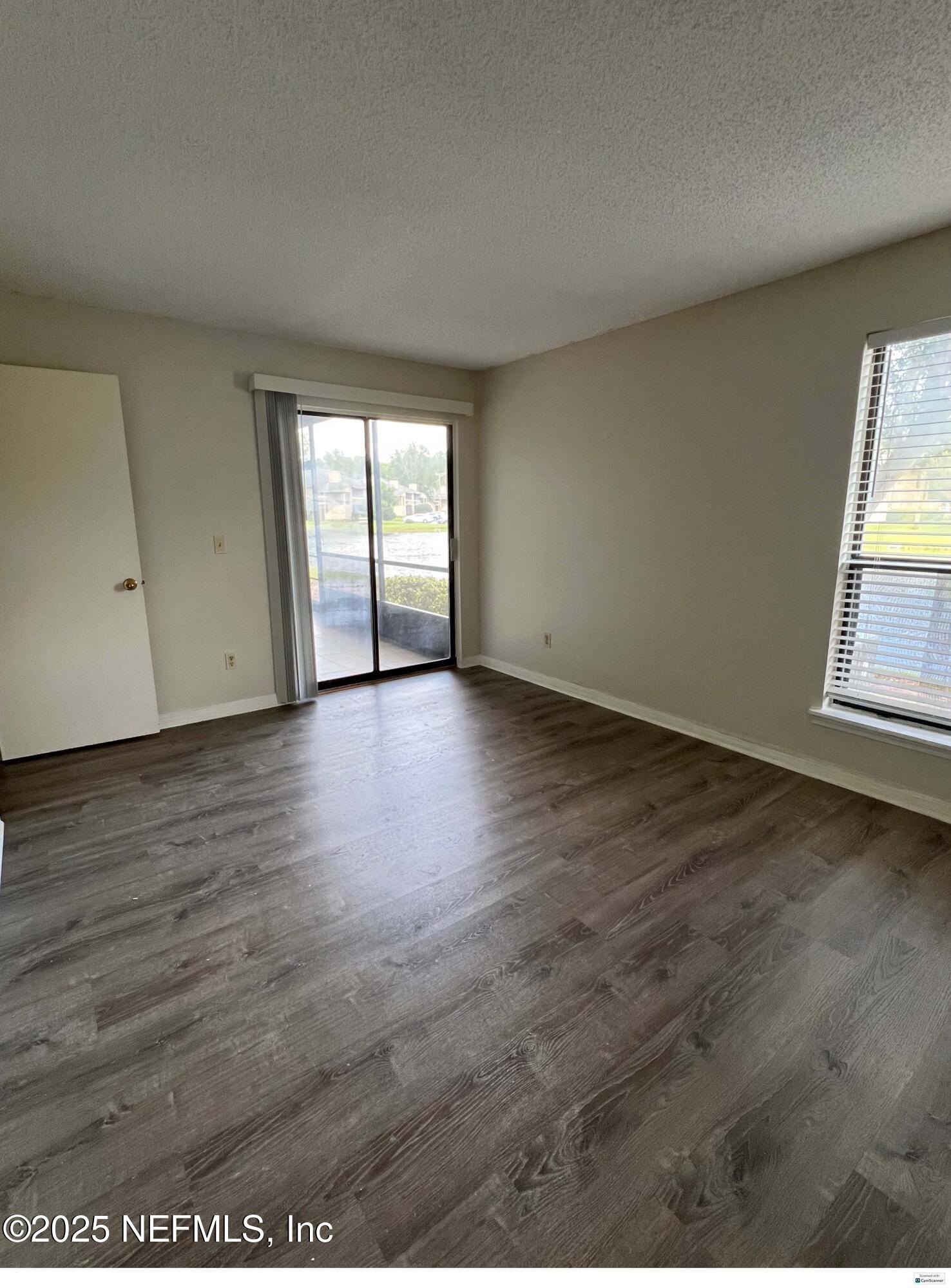 10200 Belle Rive Boulevard, Unit 83 Jacksonville, FL 32256 - Photo 4 of 21 an empty room with wooden floor and windows