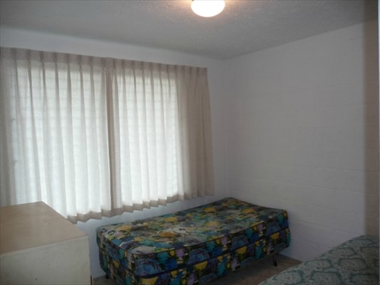 272 Kapiolani Street, Unit 204 Hilo, HI 96720 - Photo 7 of 10 a bedroom with a bed and a window