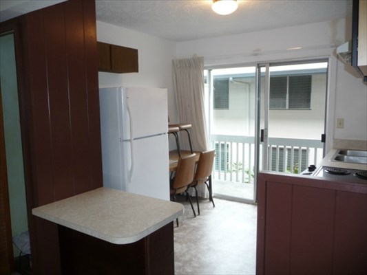 272 Kapiolani Street, Unit 204 Hilo, HI 96720 - Photo 9 of 10 a kitchen with stainless steel appliances a refrigerator and a table