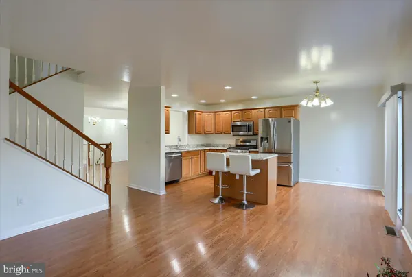 a kitchen with granite countertop kitchen island wooden cabinets and stainless steel appliances