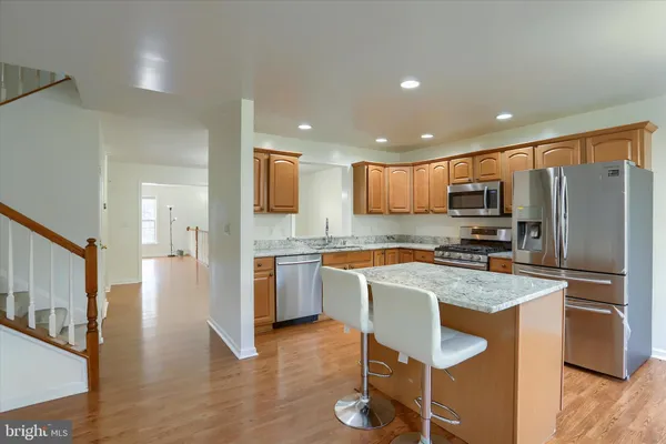 a kitchen with granite countertop a center island stainless steel appliances cabinets and a counter top space
