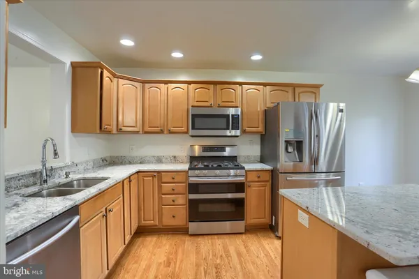 a kitchen with stainless steel appliances granite countertop a sink stove and cabinets