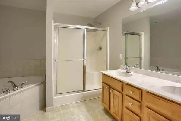 a bathroom with a tub a sink and a shower