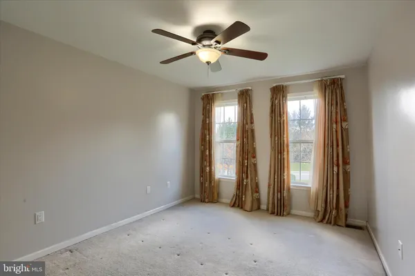 an empty room with closet and a chandelier fan
