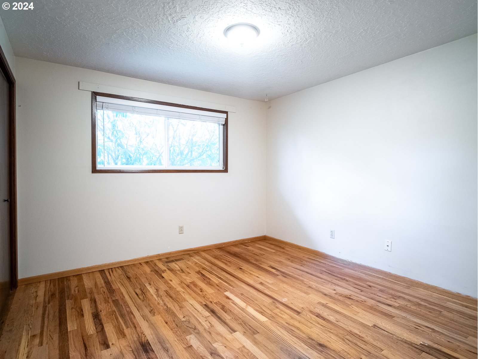 3238 Southeast 176th Place Portland, OR 97236 - Photo 12 of 31 an empty room with wooden floor and windows
