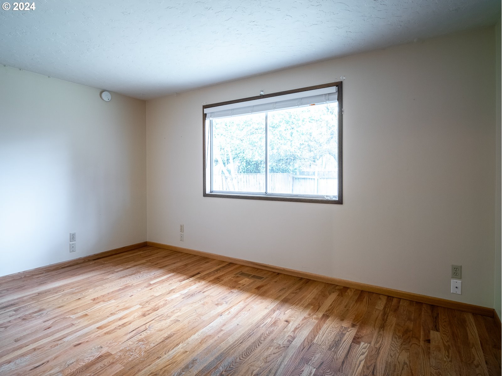 3238 Southeast 176th Place Portland, OR 97236 - Photo 16 of 31 a view of an empty room with wooden floor and a window