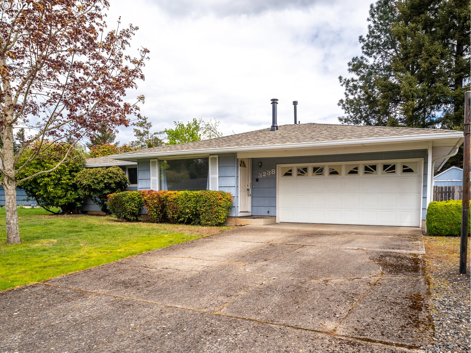 3238 Southeast 176th Place Portland, OR 97236 - Photo 27 of 31 a front view of a house with a yard and garage