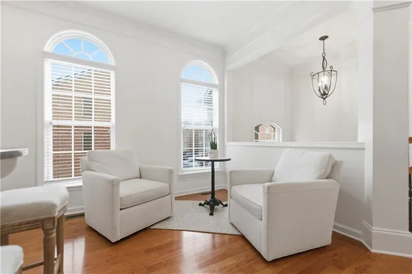 a dining room with furniture a chandelier and wooden floor