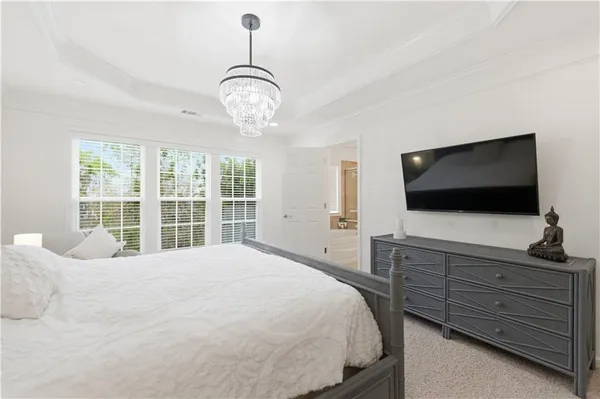 a spacious bedroom with a bed and a flat screen tv